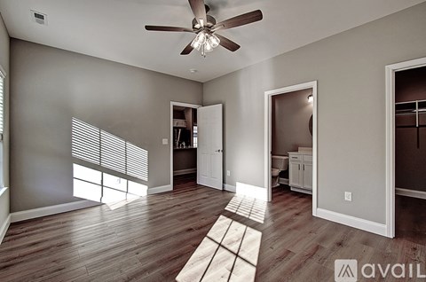 A room with a ceiling fan and wooden flooring.