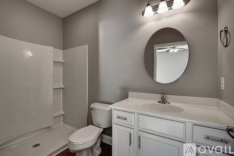 A bathroom with a toilet, sink, and mirror.