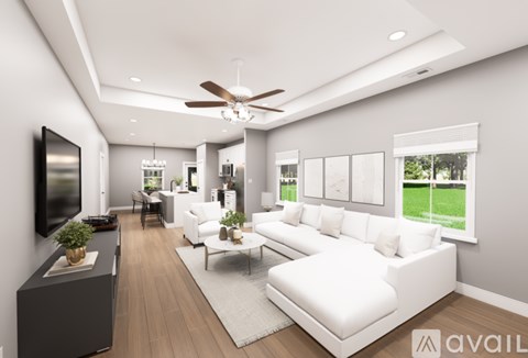 A modern living room with a white sofa and a flat screen TV mounted on the wall.