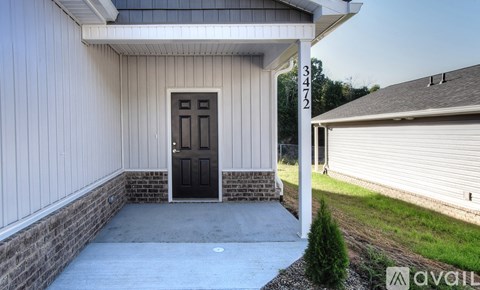 A house with a black door and a white wall is available for rent.