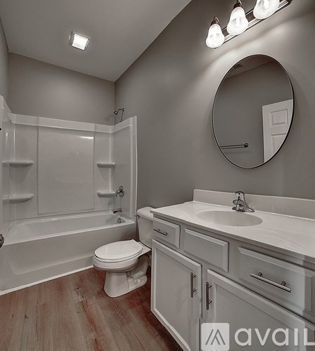 A bathroom with a toilet, sink, and mirror.