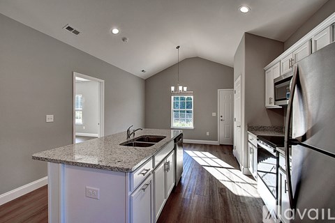 A kitchen with a granite countertop and wooden flooring.