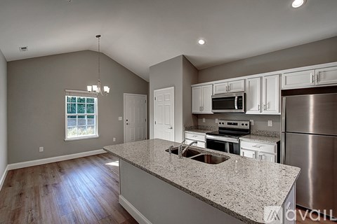 A kitchen with a granite countertop and stainless steel appliances.