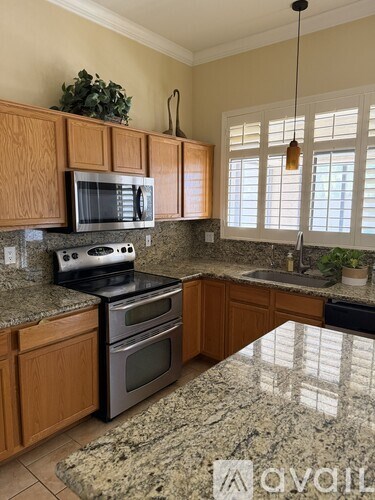 A kitchen with granite countertops and wooden cabinets.