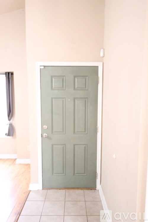 A green door is in a room with white walls.