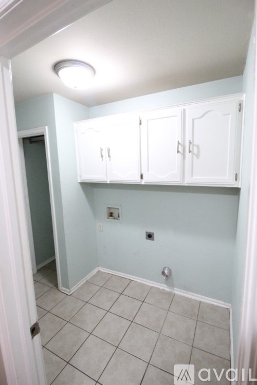 A room with white cabinets and a tiled floor.
