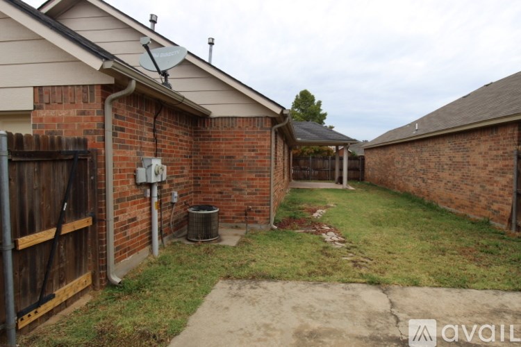 A backyard with a brick wall and a satellite dish on the roof.