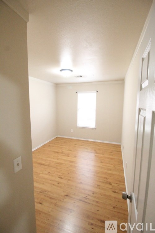 A room with wooden flooring and a window.