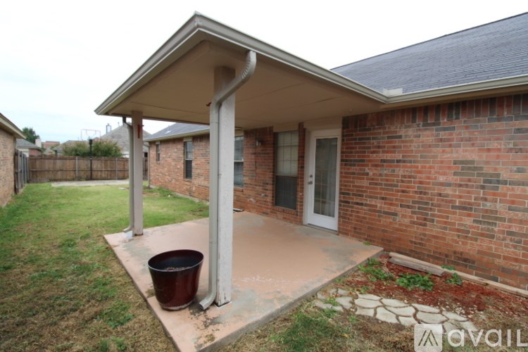 A red brick house with a white covered patio.