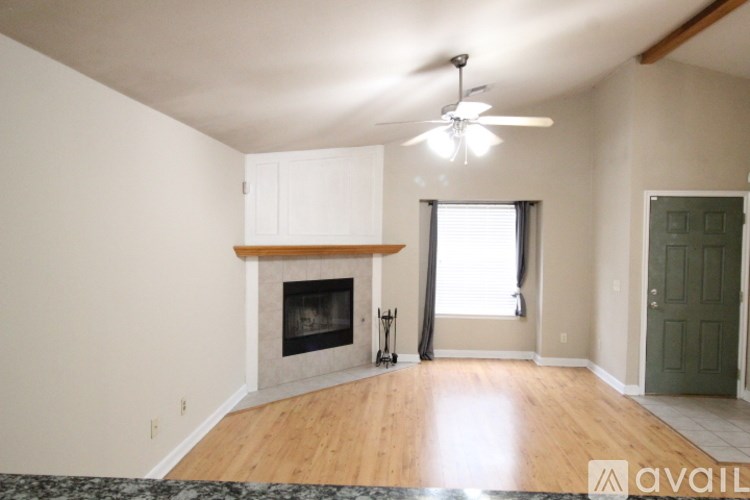 A living room with a fireplace and a ceiling fan.