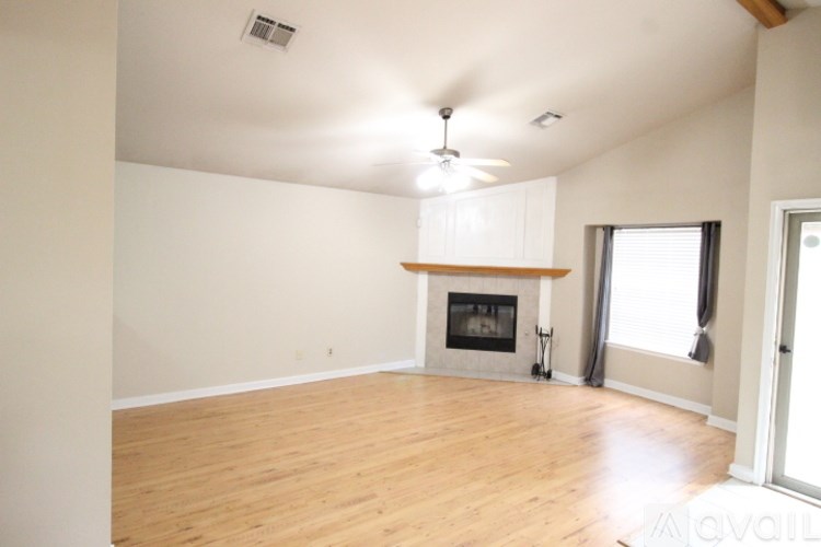 A living room with a fireplace and a ceiling fan.