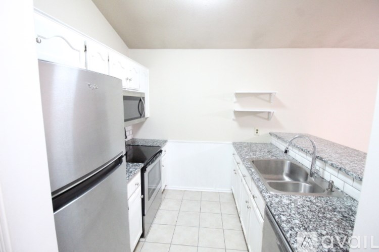 A kitchen with a stainless steel refrigerator, microwave, and dishwasher.