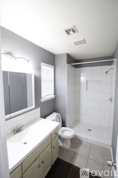 A bathroom with a toilet, sink, and shower.