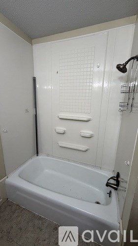 A white bathroom with a bathtub and a shower head.
