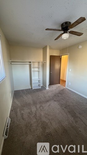 A room with a ceiling fan and a carpeted floor.