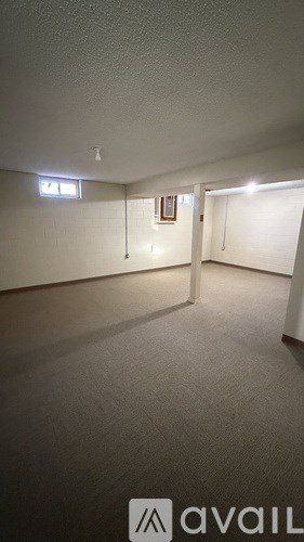 A room with a white wall and a light switch.