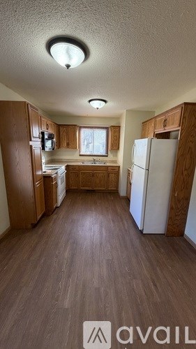 A kitchen with wooden cabinets and a white refrigerator.
