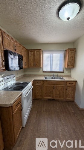 A kitchen with wooden cabinets and a white stove top oven.