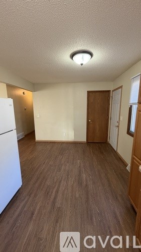 A kitchen with a white refrigerator and wooden floors.