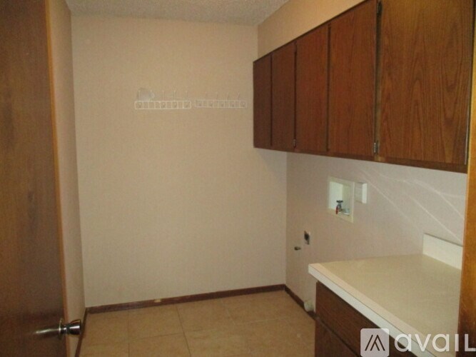 A kitchen with wooden cabinets and a white counter.