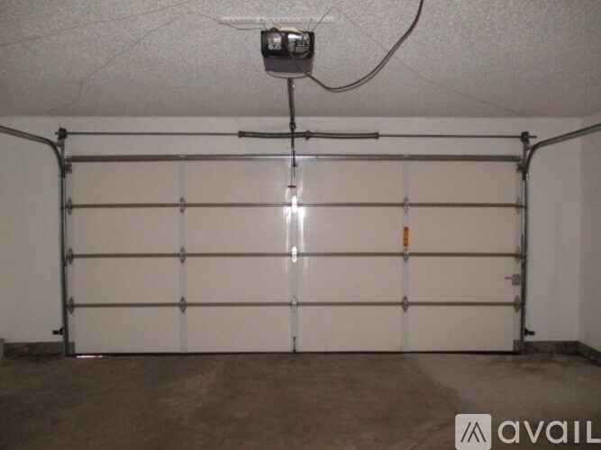 A garage door with a white interior and a black security camera mounted on the ceiling.