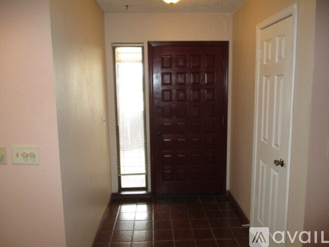 A hallway with a brown door and a white door.