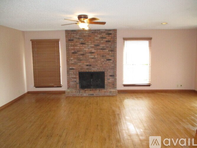 A living room with a fireplace and wooden floors.