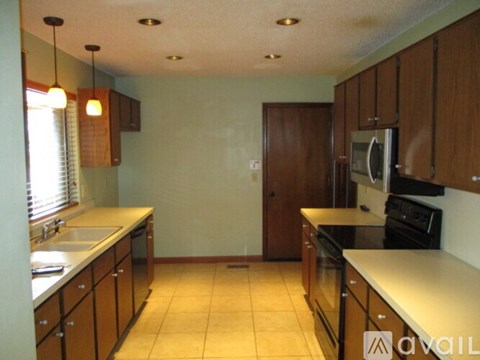 A kitchen with wooden cabinets and a white counter top.