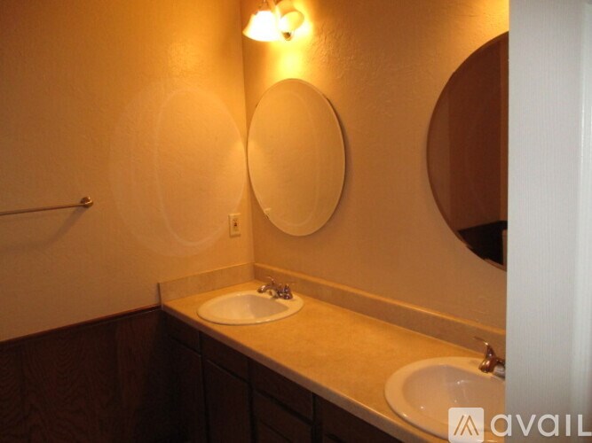 A bathroom with a sink and two mirrors.