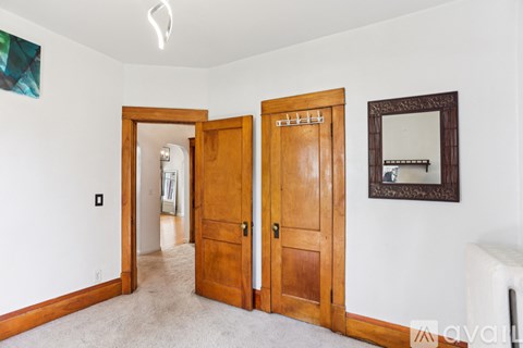 A room with a white wall and a wooden door.