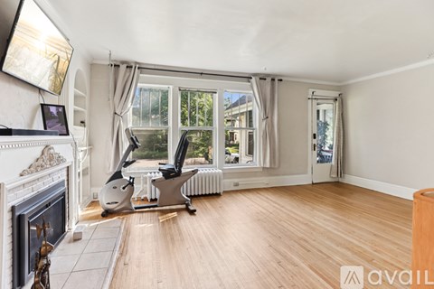 A room with a fireplace, a chair, and a window with curtains.