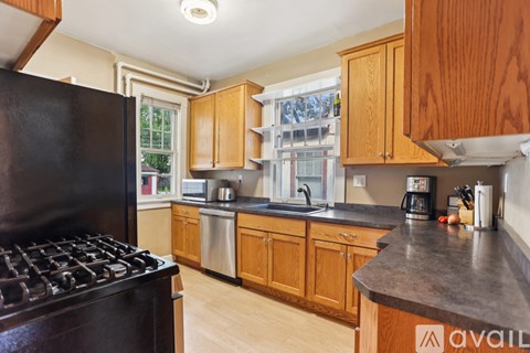 A kitchen with wooden cabinets and a black stove top.
