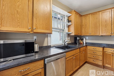 A kitchen with wooden cabinets and a black countertop.