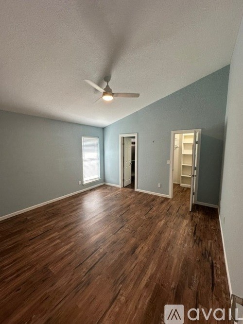 A room with wooden floors and a ceiling fan.