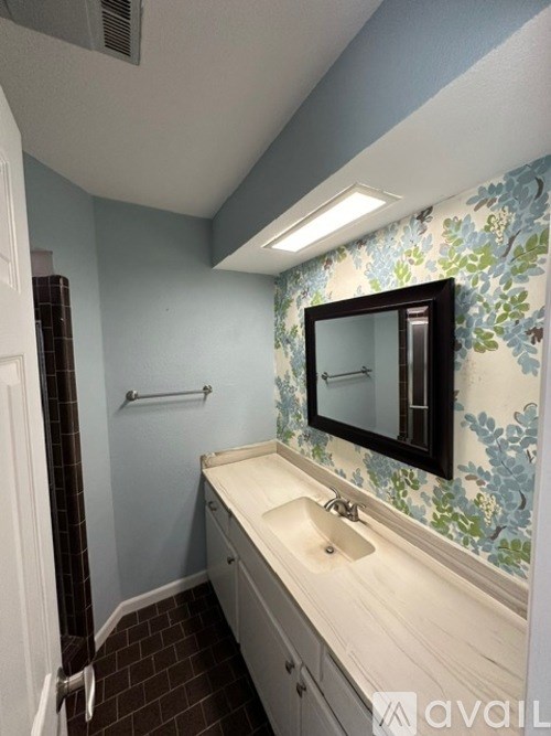 A bathroom with a sink, mirror, and tiled floor.