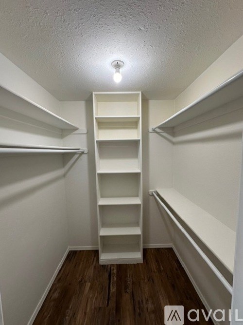 A white closet with shelves and a light on.
