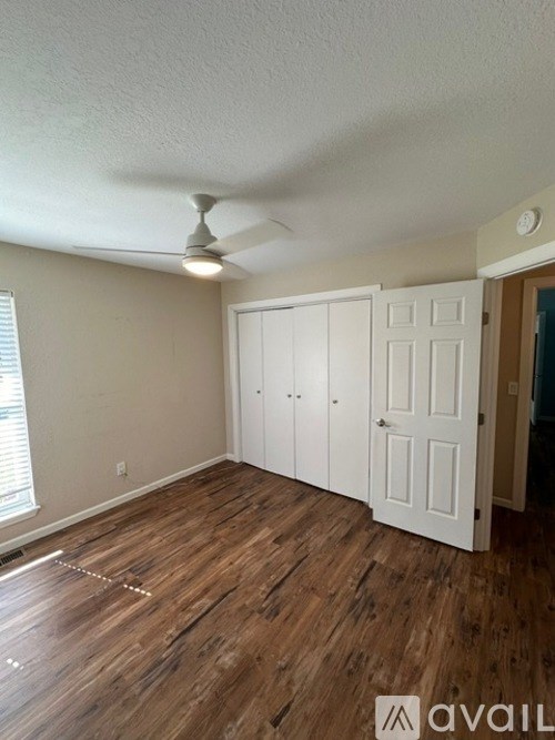 A room with wooden floors and a ceiling fan.