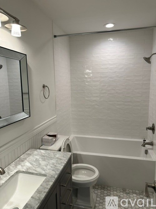 A bathroom with a toilet, sink, and bathtub.