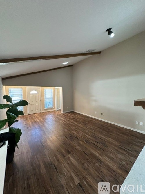 A room with wooden flooring and a ceiling light.