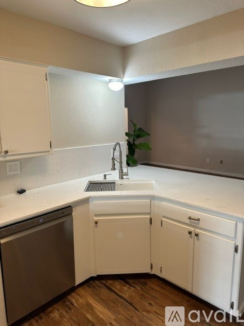 A kitchen with white cabinets and a stainless steel dishwasher.