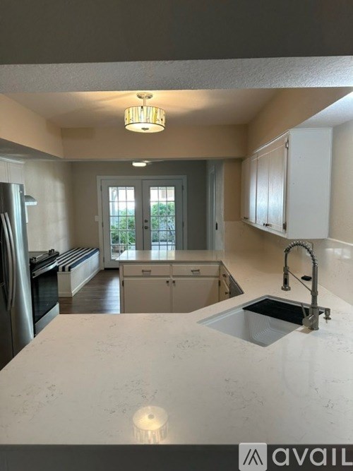 A kitchen with a marble countertop and stainless steel appliances.
