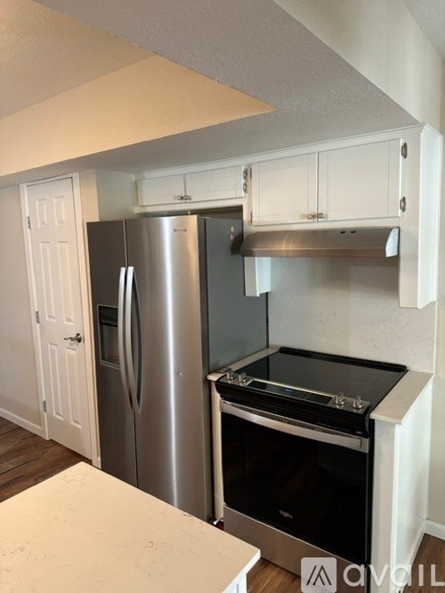 A kitchen with a stainless steel refrigerator and black oven.