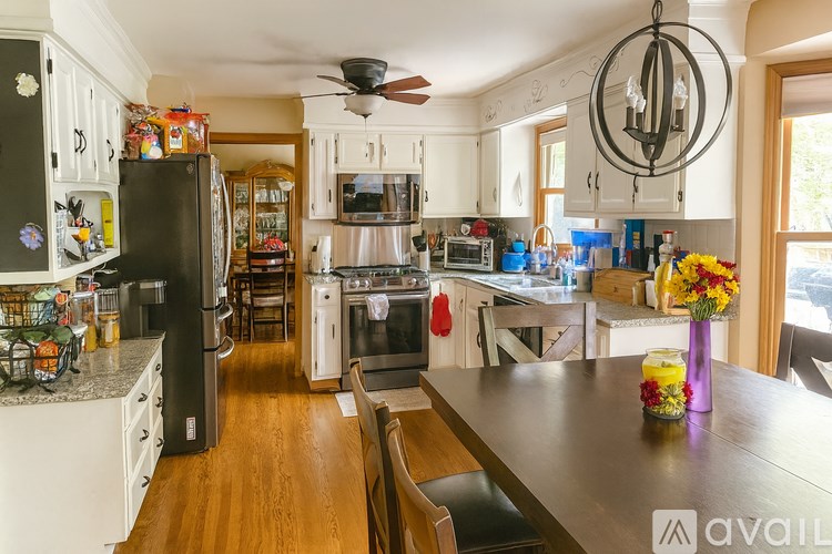 A kitchen with a black fridge and a wooden table.
