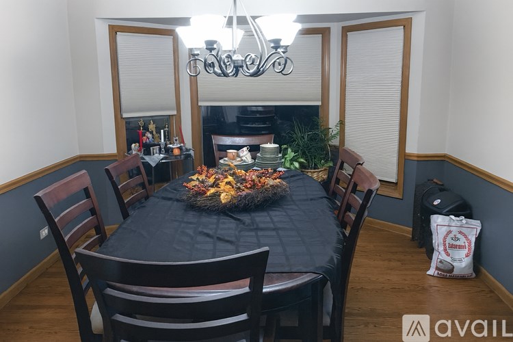 A dining table with chairs and a chandelier in a room.