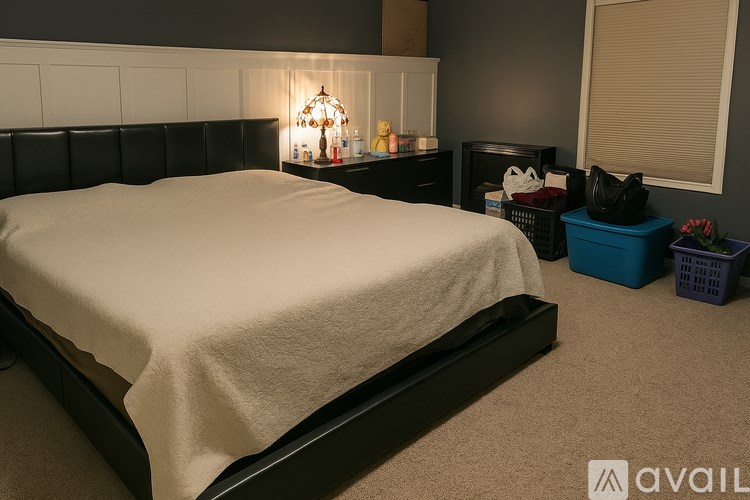 A bedroom with a bed, nightstand, and a lamp.