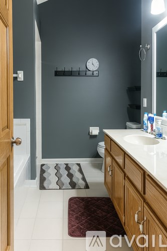 A bathroom with a toilet, sink, and a mirror.