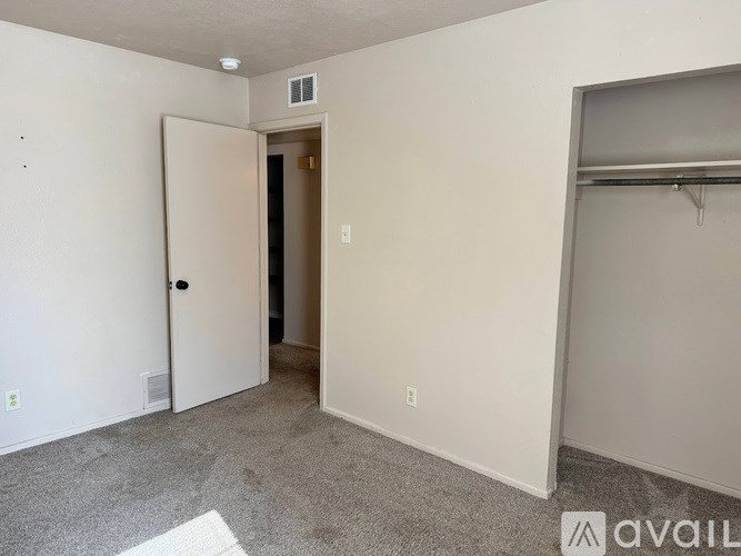 A room with a carpeted floor and a white door.