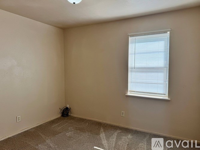 A room with a window and a fan on the ceiling.