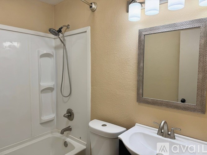 A bathroom with a white tub, toilet, and sink.