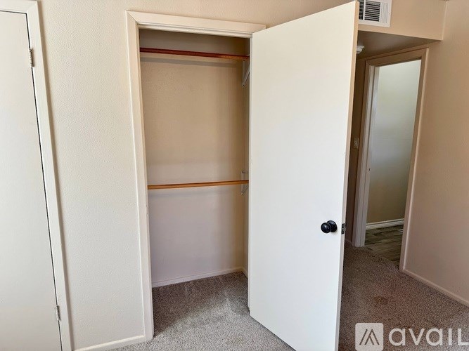 A white door is open to a room with a carpeted floor.